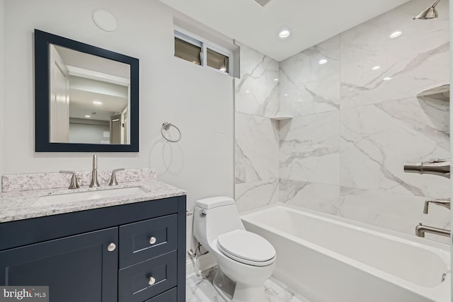 full bathroom featuring tiled shower / bath, vanity, and toilet