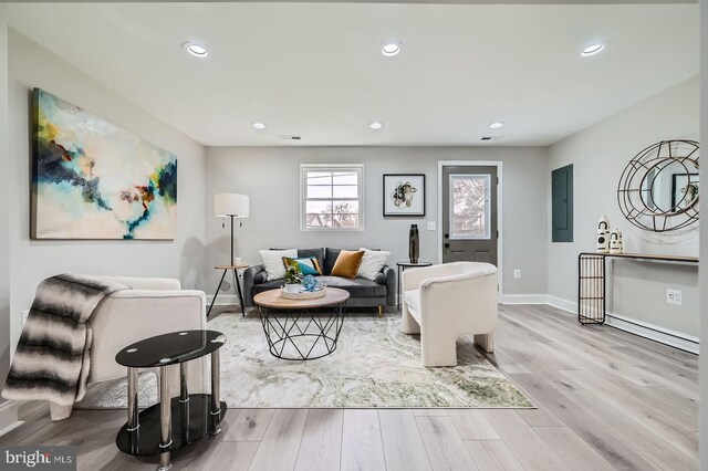 below grade area with baseboards, light wood finished floors, and electric panel