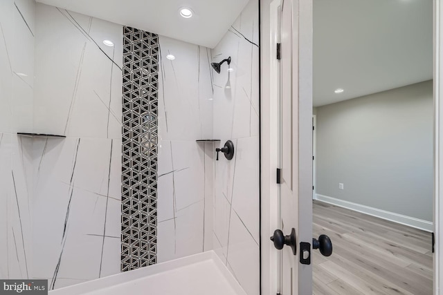 bathroom featuring hardwood / wood-style floors and tiled shower