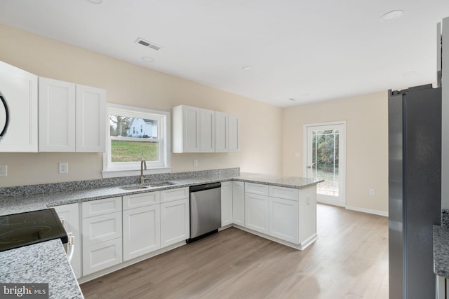 kitchen with white cabinetry, a wealth of natural light, sink, and appliances with stainless steel finishes