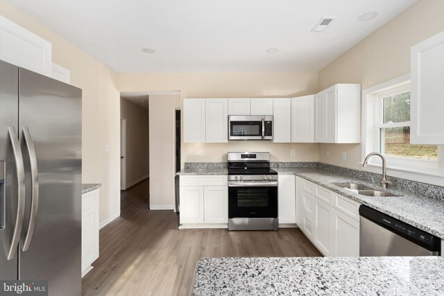 35 Grinnan Ln, Fredericksburg, VA 22406 - kitchen featuring appliances with stainless steel finishes, light stone countertops, wood finished floors, and white cabinets