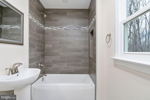 bathroom with tiled shower / bath combo and sink