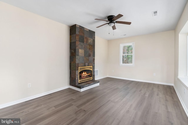 unfurnished living room with a tile fireplace, ceiling fan, and hardwood / wood-style flooring