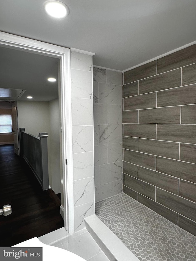 bathroom featuring hardwood / wood-style floors and a tile shower