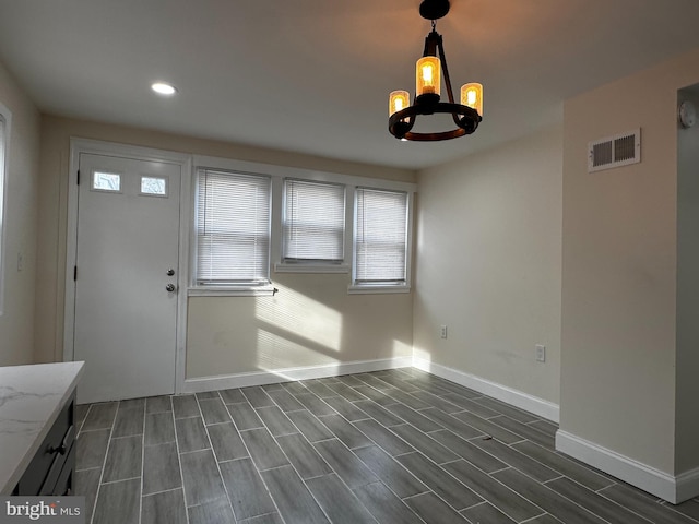 interior space featuring dark wood-type flooring and a chandelier