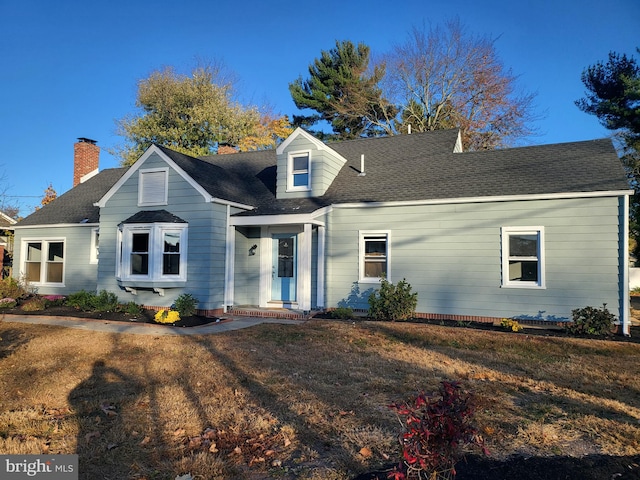 cape cod-style house featuring a front yard