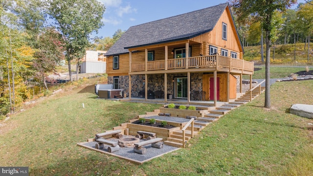 back of house featuring a patio, an outdoor fire pit, a deck, and a lawn