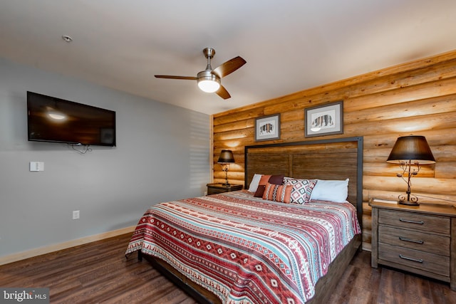 bedroom with log walls, dark hardwood / wood-style floors, and ceiling fan