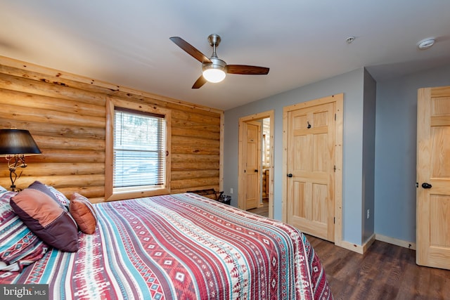 bedroom with log walls, dark hardwood / wood-style floors, and ceiling fan