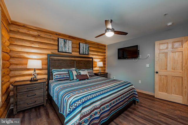 bedroom with dark wood-type flooring, rustic walls, and ceiling fan