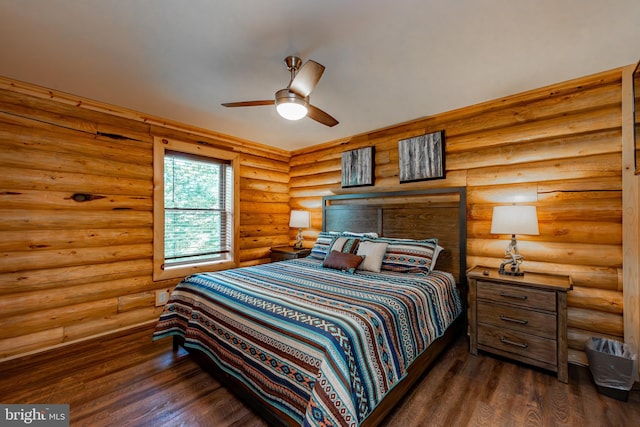 bedroom featuring dark hardwood / wood-style floors, log walls, and ceiling fan