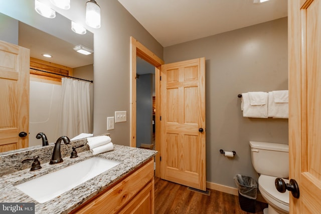 bathroom featuring toilet, hardwood / wood-style floors, and vanity