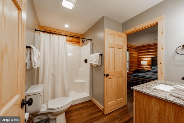 bathroom with toilet, a shower with curtain, vanity, hardwood / wood-style flooring, and rustic walls