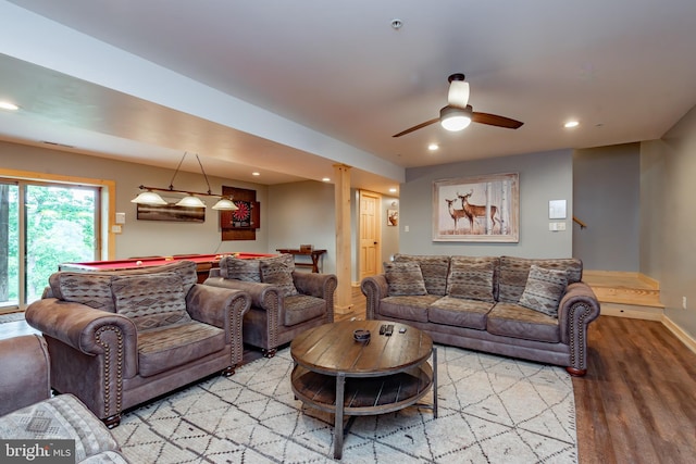 living room featuring ceiling fan, light hardwood / wood-style flooring, and bar area