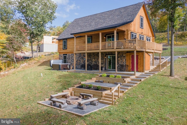 rear view of house featuring a yard, an outdoor fire pit, and a wooden deck