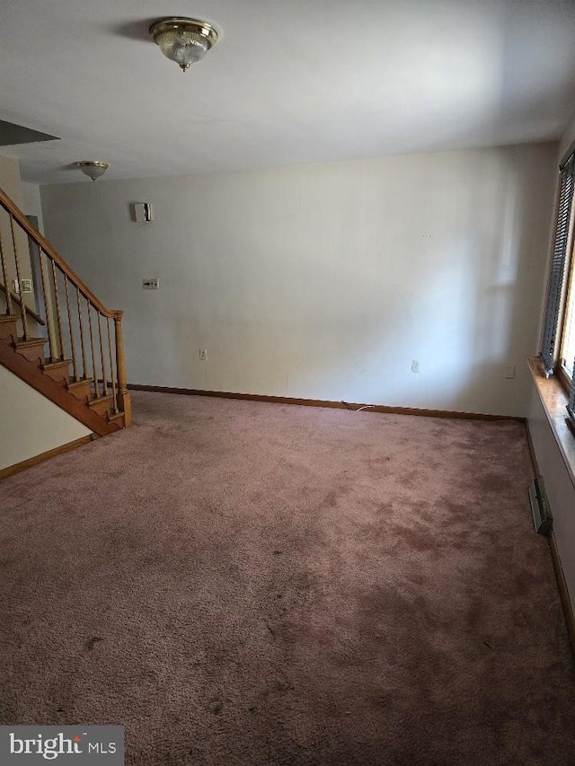 unfurnished living room with dark colored carpet