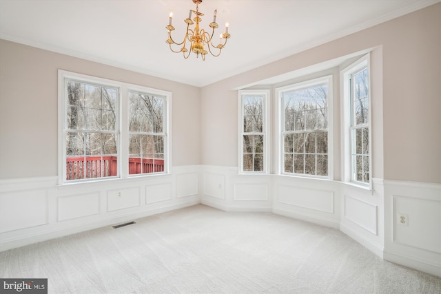 unfurnished dining area with carpet flooring, a notable chandelier, and ornamental molding