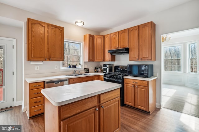 kitchen with sink, a center island, a wealth of natural light, and black appliances