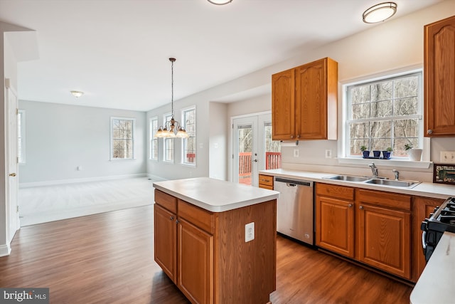 kitchen with dishwasher, hanging light fixtures, an inviting chandelier, a kitchen island, and hardwood / wood-style flooring