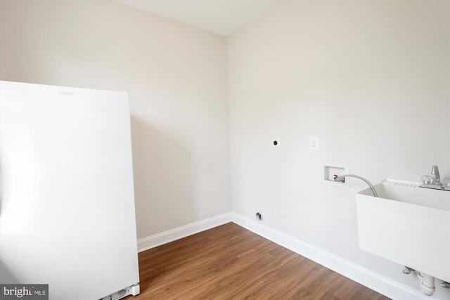 laundry area featuring hookup for an electric dryer, washer hookup, hardwood / wood-style flooring, and sink