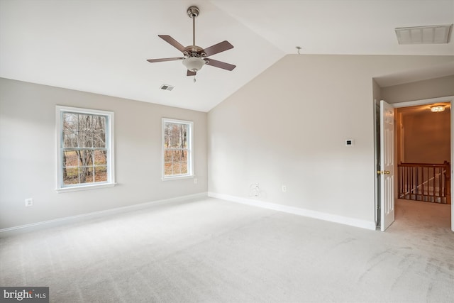 spare room featuring light colored carpet, ceiling fan, and lofted ceiling