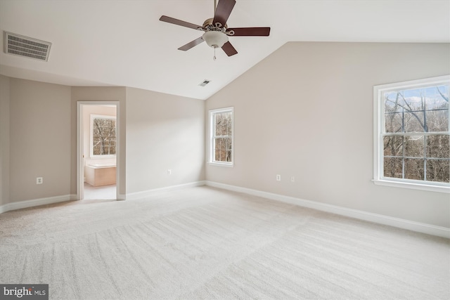 unfurnished bedroom featuring connected bathroom, ceiling fan, light colored carpet, and lofted ceiling