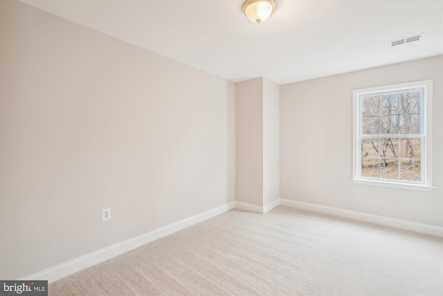 unfurnished room featuring light carpet