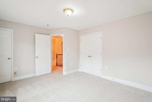 unfurnished bedroom featuring light carpet