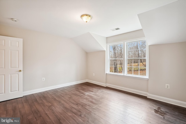 bonus room with lofted ceiling and dark hardwood / wood-style floors