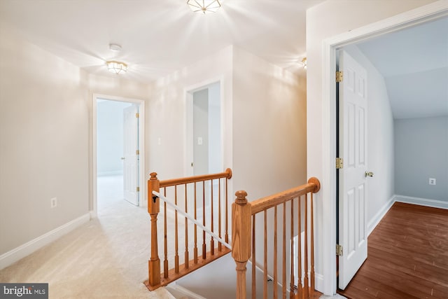 hallway with hardwood / wood-style flooring and vaulted ceiling