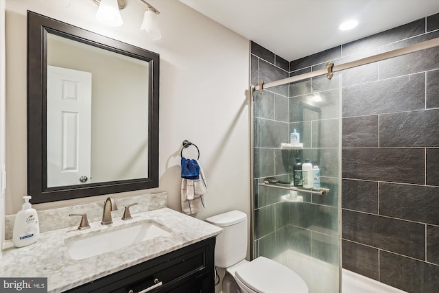 bathroom featuring vanity, toilet, and walk in shower