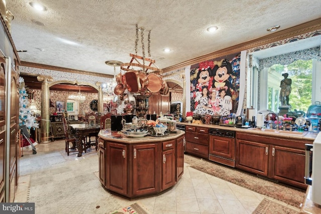 kitchen with crown molding, a center island, sink, pendant lighting, and a textured ceiling