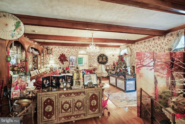 dining room featuring beam ceiling, a textured ceiling, wood-type flooring, and a chandelier