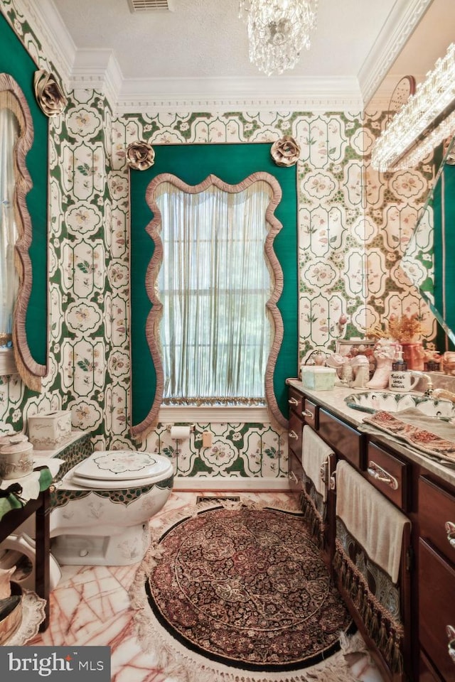 bathroom featuring vanity, a textured ceiling, ornamental molding, and toilet