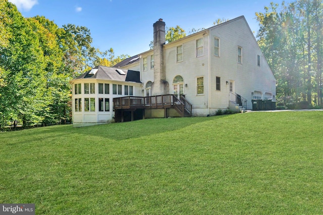 rear view of property with a deck and a lawn