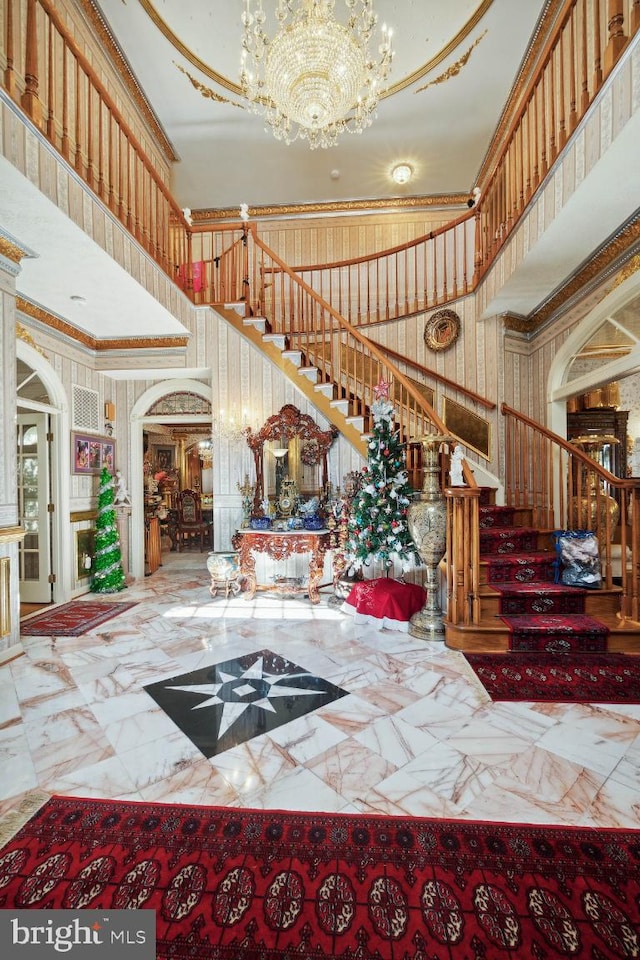 foyer entrance featuring ornamental molding and a towering ceiling