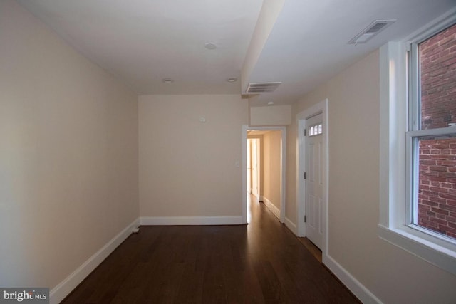 hall featuring a wealth of natural light and dark hardwood / wood-style flooring