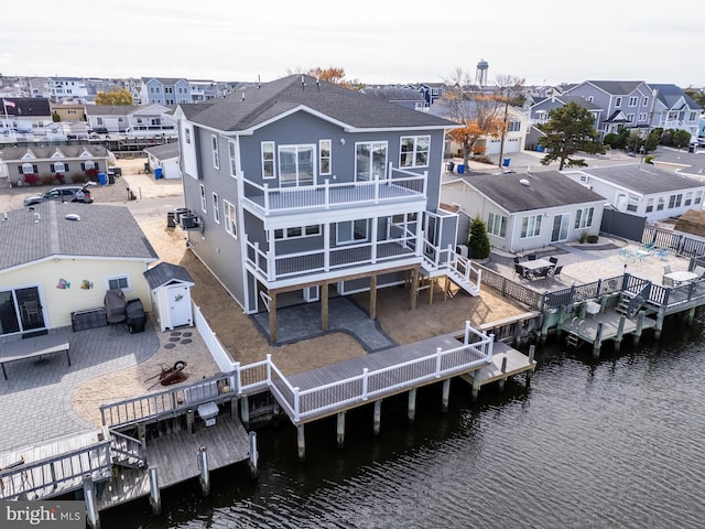 exterior space with a deck with water view and a patio