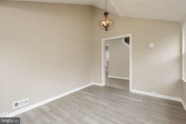 unfurnished room featuring light hardwood / wood-style floors, a chandelier, and vaulted ceiling