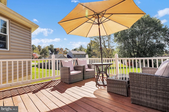 wooden terrace featuring an outdoor living space and a yard