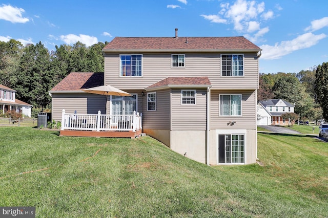 rear view of property with a lawn and a wooden deck