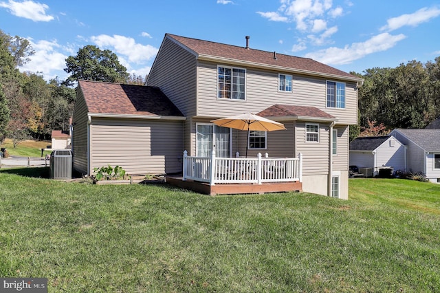 rear view of house with a yard, a deck, and central AC unit