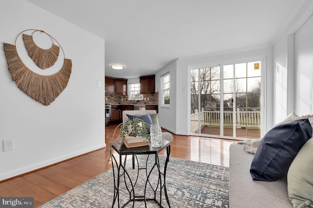 living room with ornamental molding, a healthy amount of sunlight, and hardwood / wood-style flooring