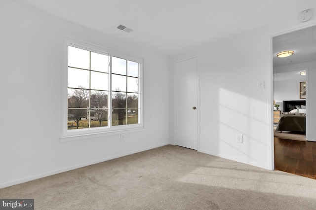 carpeted empty room featuring plenty of natural light