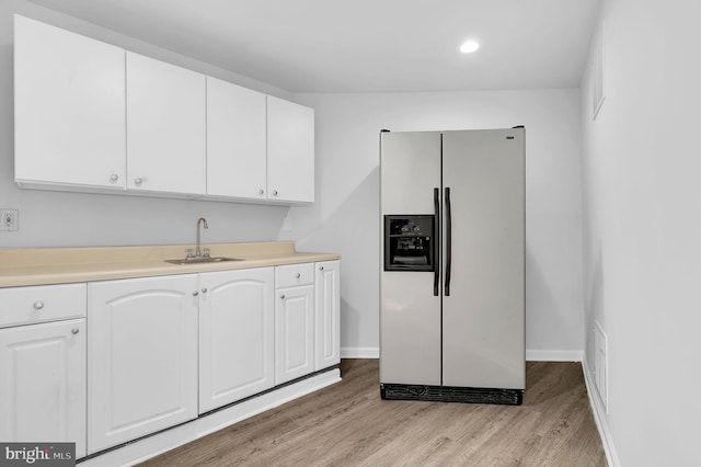 kitchen featuring fridge with ice dispenser, sink, white cabinets, and light hardwood / wood-style floors