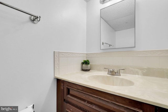 bathroom with a paneled ceiling and vanity