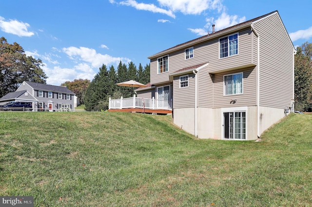 back of house with a lawn and a deck