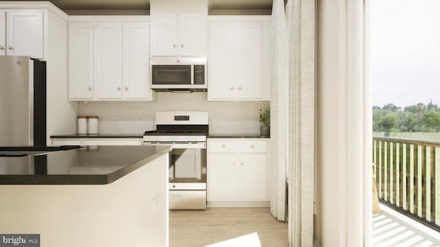 kitchen featuring white cabinetry, backsplash, appliances with stainless steel finishes, and light hardwood / wood-style flooring