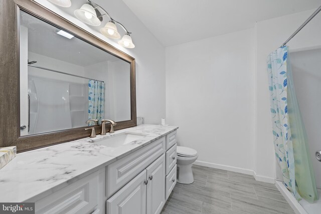 bathroom with a shower with curtain, vanity, and toilet