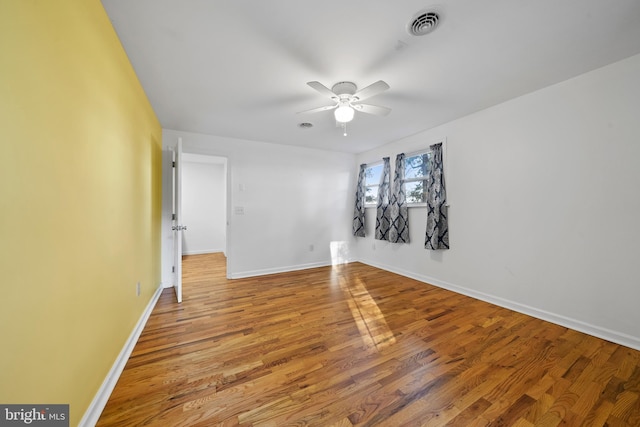 empty room with ceiling fan and hardwood / wood-style flooring